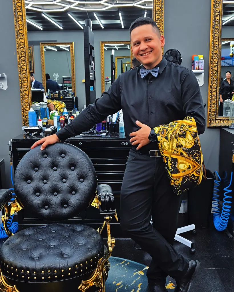 Luis beside one of the gilded barber chairs