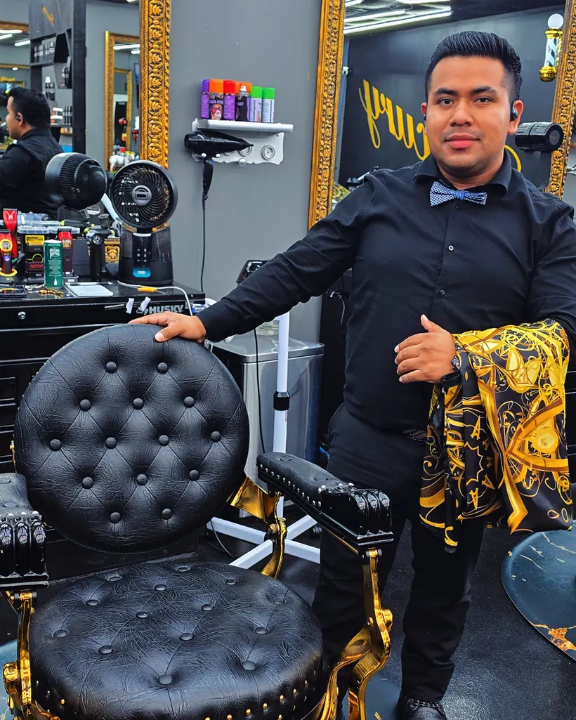 Lyman beside one of the gilded barber chairs