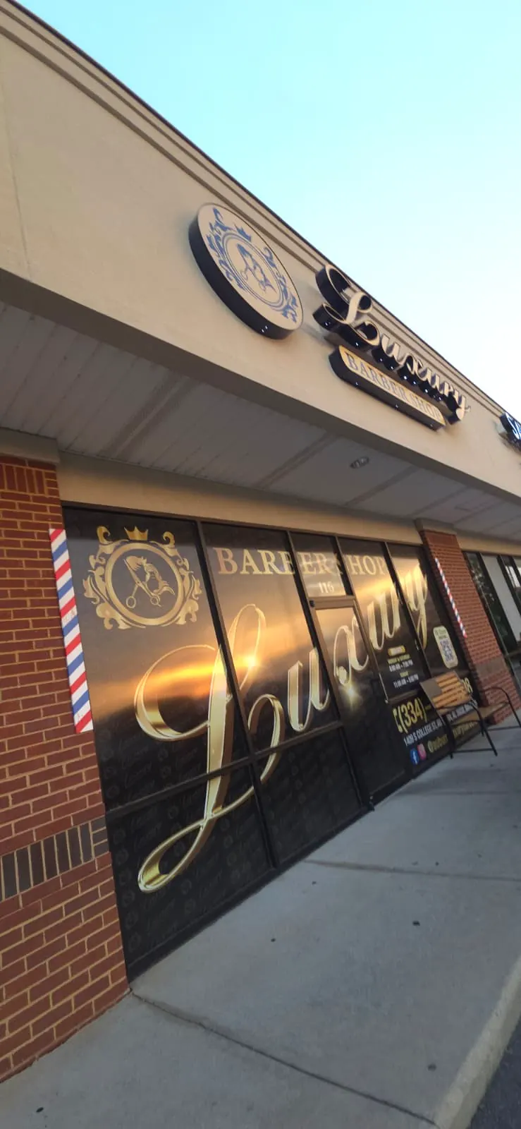 The shopfront at night, gold lettering on the window